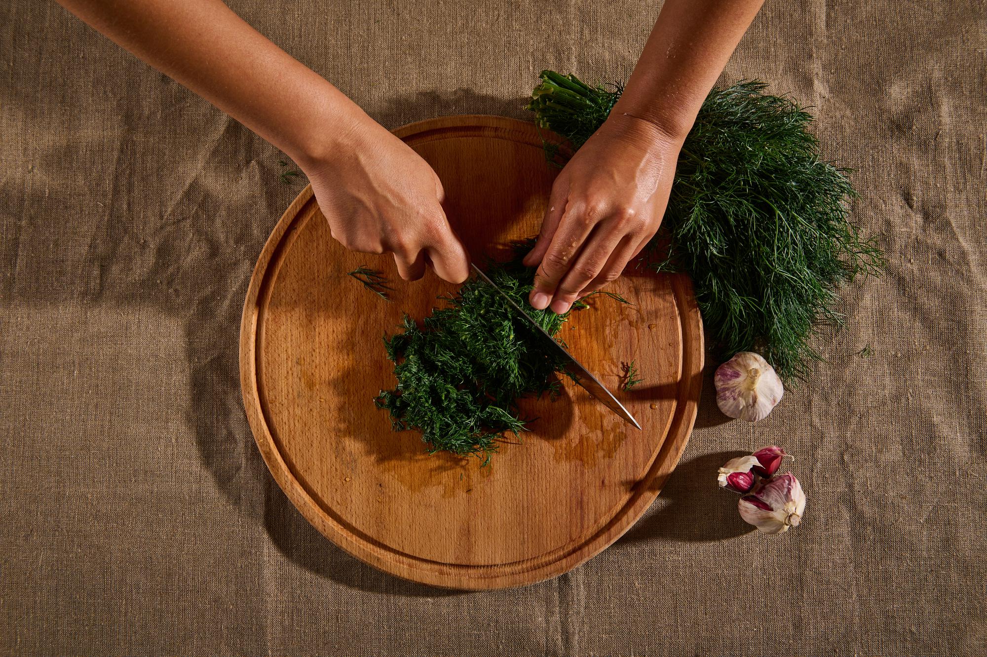 Hands preparing fresh ingredients on wooden board