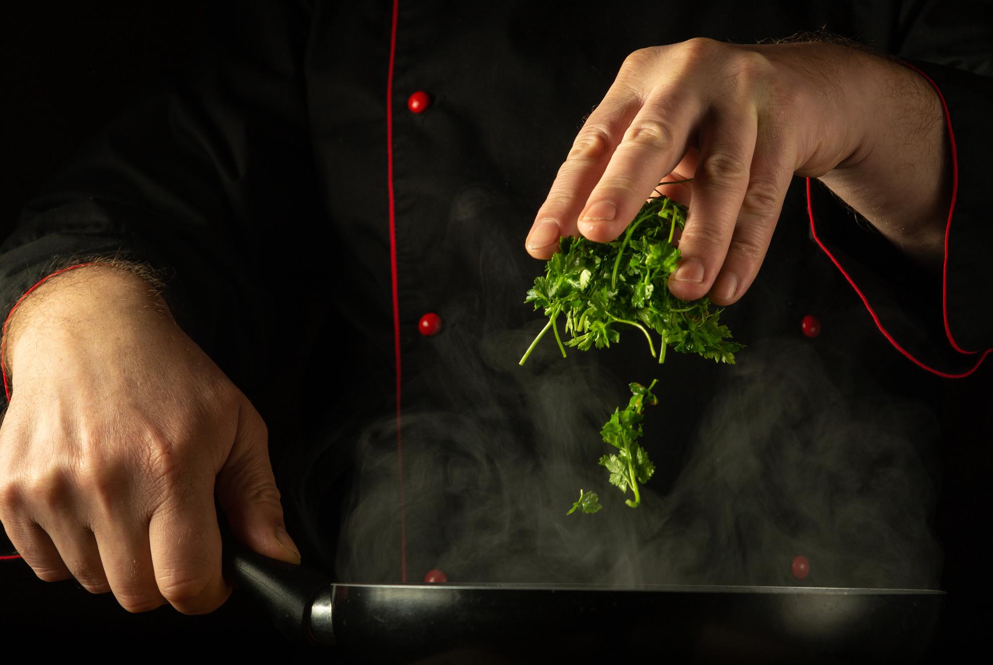 Chef slicing herbs for garnish